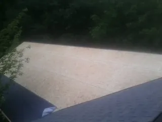 New OSB roof sheathing installed beside an existing shingle roof in Chesterhill