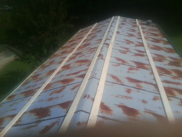 Rusted metal roof panels with new wood purlins before replacement — Storm Damage Roof Repair in Chesterhill by Roofing Brothers