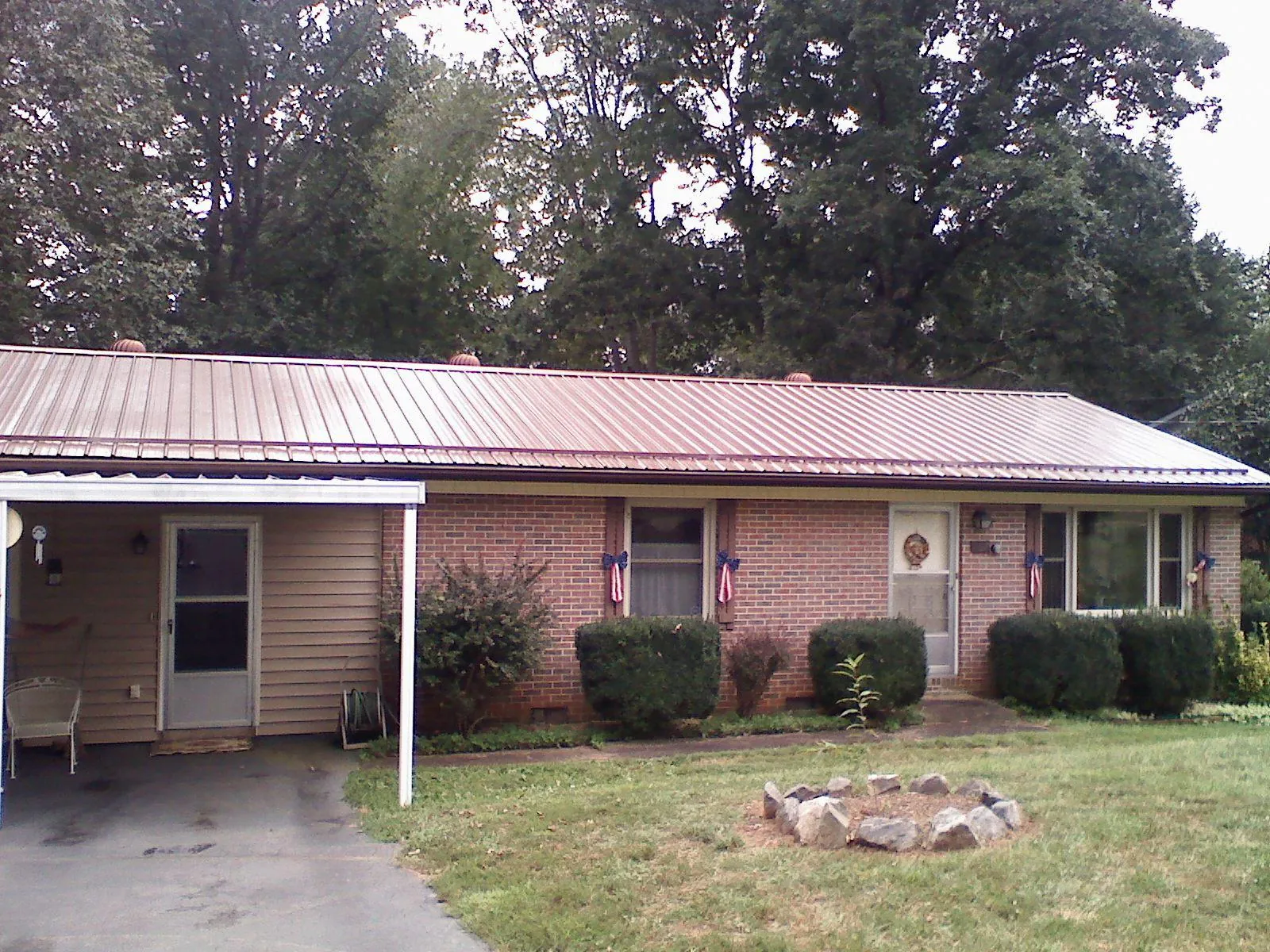 Bronze metal roof and carport on a brick ranch home — Roof Repair work by our crew in Chesterhill